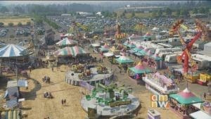 Aerial view of a county fair with rides, tents, and vendor booths