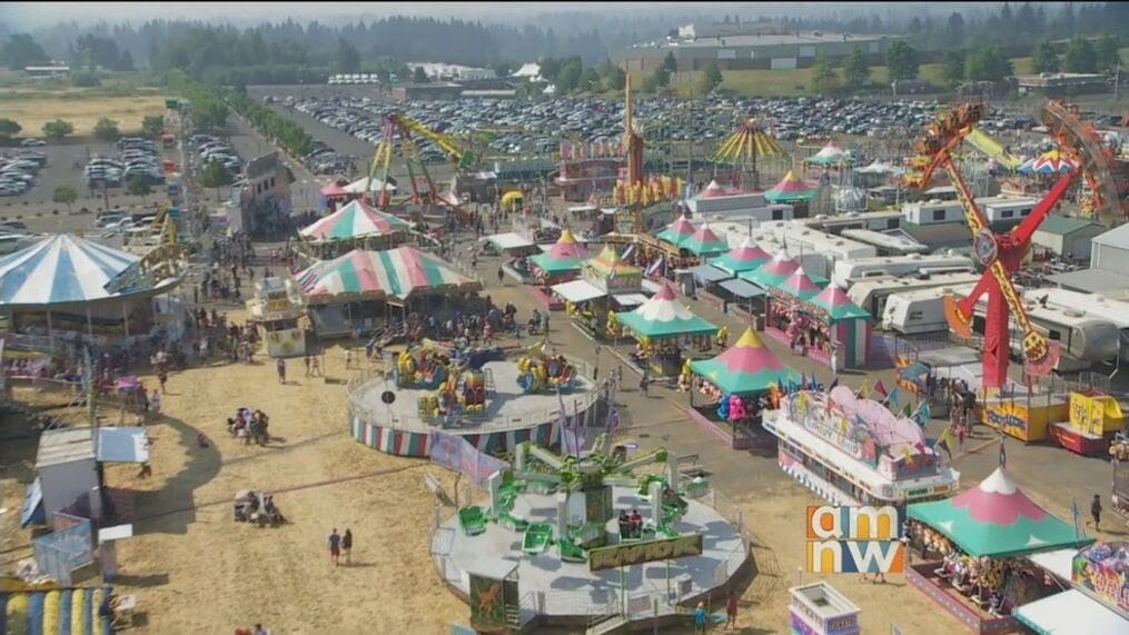 Aerial view of a county fair with rides, tents, and vendor booths