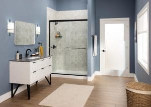 Modern bathroom with gray stone-look shower walls, white vanity, and glass enclosure