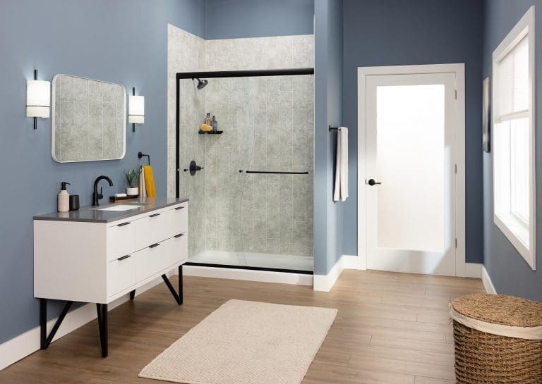Modern bathroom with gray stone-look shower walls, white vanity, and glass enclosure