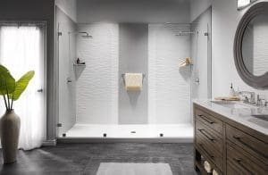 Walk-in shower with light gray walls, white base, wood vanity, and window