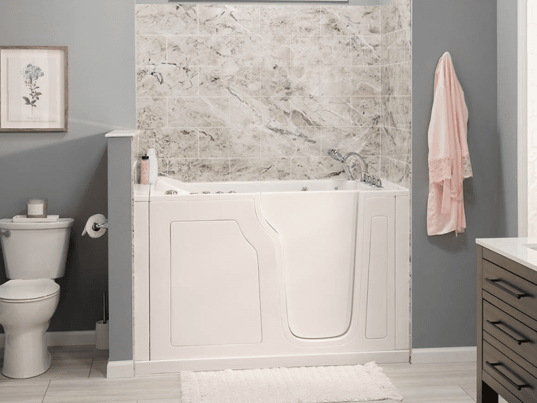 White walk-in bathtub with marble-look wall surround and chrome fixtures