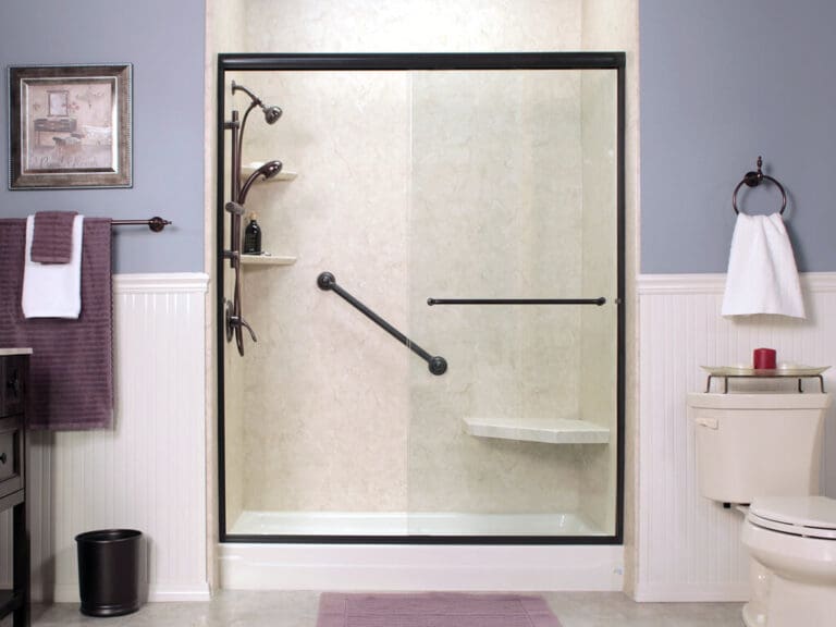 Accessible white shower with sliding glass door, grab bar, corner seat, and shelf